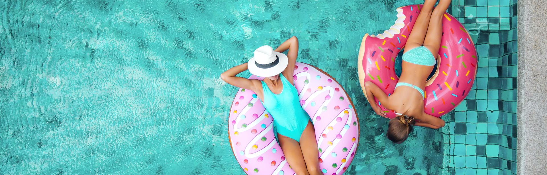 Frauen liegen auf Ringen im Wasser