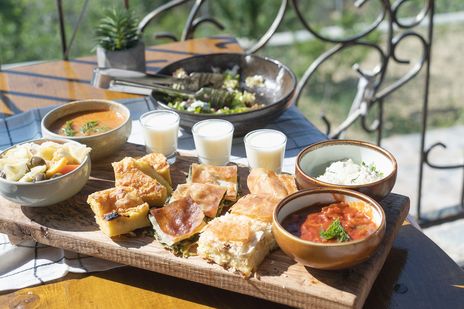 Auswahl traditioneller albanischer Gerichte wie Byrek, Buttermilch, Dip und Salat