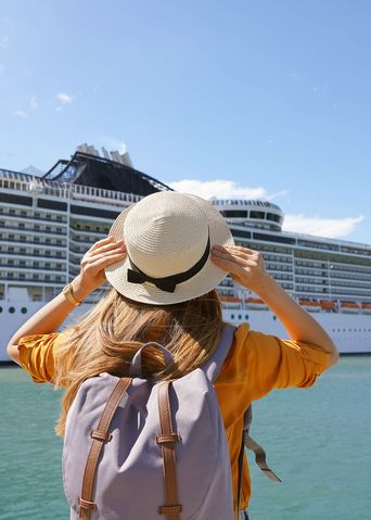 Frau blickt auf Kreuzfahrtschiff