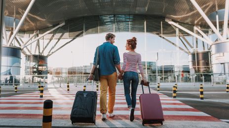 Paar mit Koffern am Flughafen
