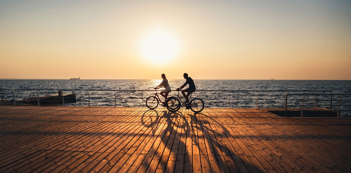 Paar beim Radfahren auf der Promenade