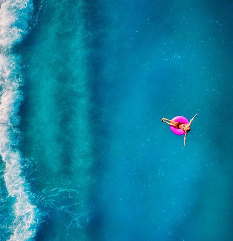 Frau auf Schwimmreifen im Meer