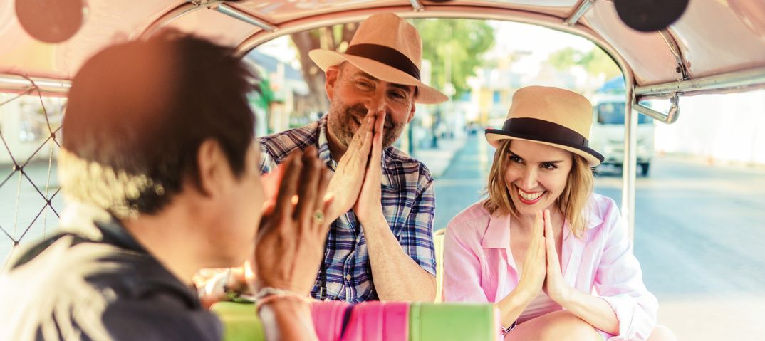 Paar sitzt gemeinsam in einem Tuk Tuk in Bangkok