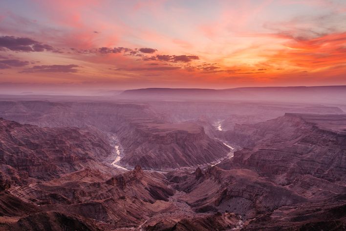 Blick über den Fish River Canyon in Namibia bei farbenprächtigem Sonnenuntergang 