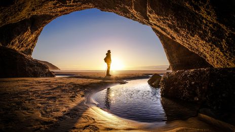 Mann in Höhle vor Sonnenuntergang