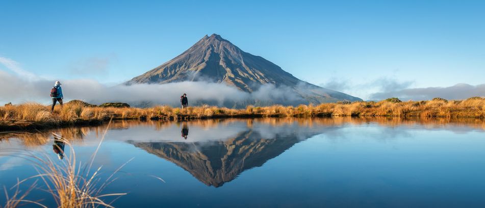 Wanderer vor dem Berg Taranaki im Egmont Nationalpark in Neuseeland