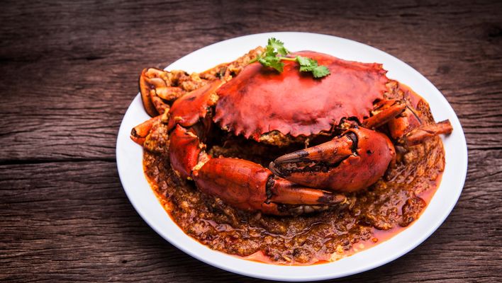 Traditionelle Chili-Krabbe als Spezialität aus Singapur serviert auf weißem Teller