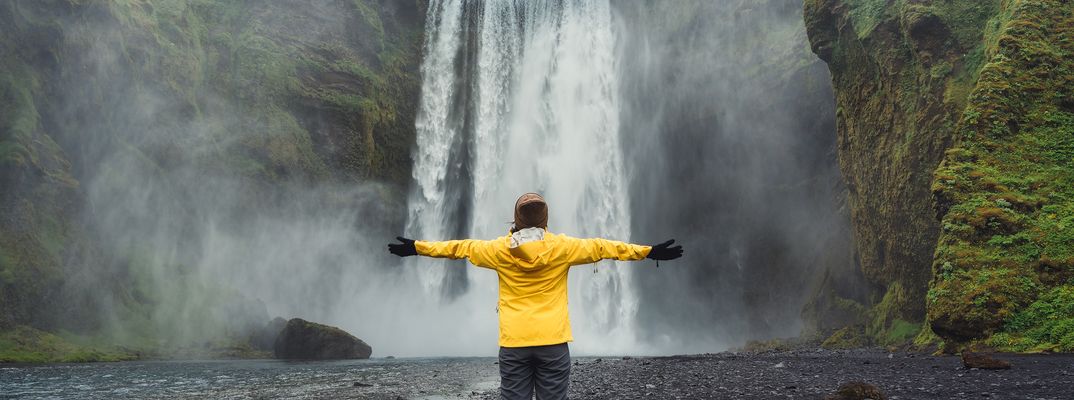 Frau vor Wasserfall auf Island
