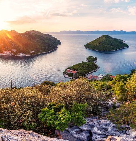 Typisches Panorama einer Bucht in Kroatien von oben betrachtet während des Sonnenuntergangs