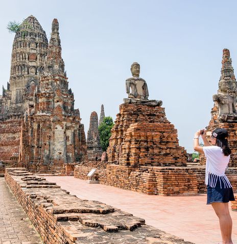 Eine Frau spaziert durch die Tempelanlage von Ayutthaya