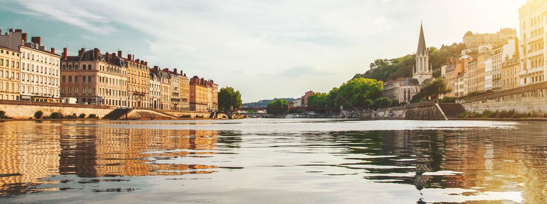 Fluss Rhône mit Stadtansicht und historischen Gebäuden bei ruhigem Licht