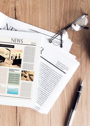 Tablet, Zeitung und Kaffee auf Holztisch