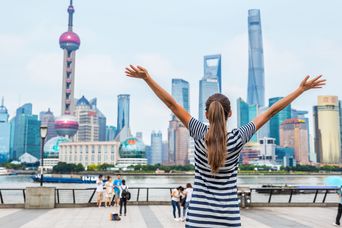 Frau steht vor Skyline von Shanghai