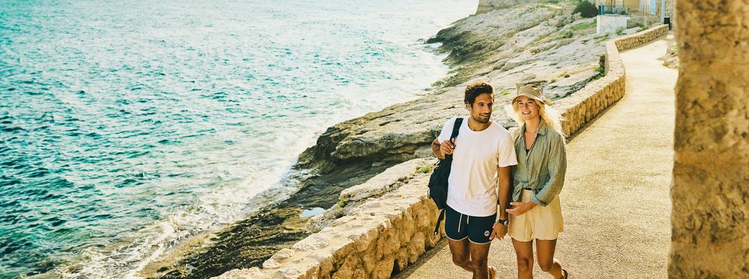 Paar spaziert entlang einer Promenade an der französischen Mittelmeerküste