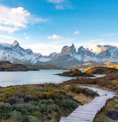 Holzsteg durch die weite Landschaft des Nationalparks Torres del Paine