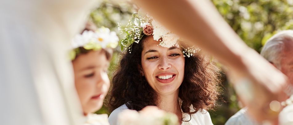 Mädchen mit Blumenkranz tanzt fröhlich beim schwedischen Mittsommerfest