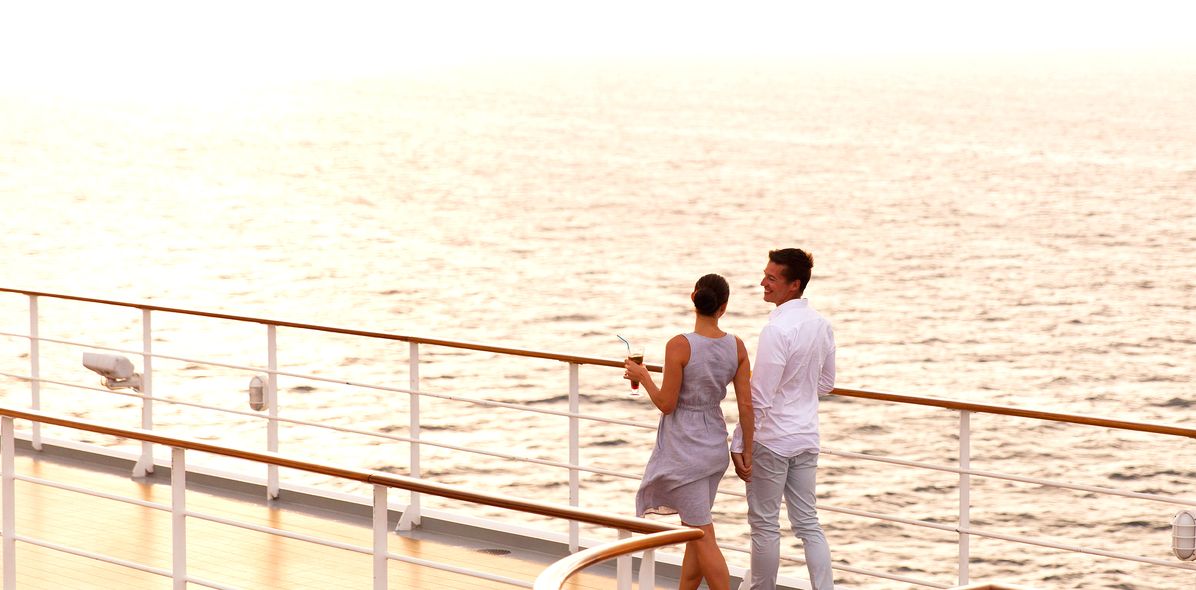 Paar geht an Deck eines Kreuzfahrtschiffes spazieren