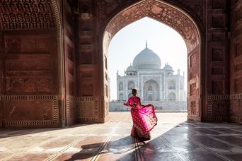 Frau im pinken Sari posiert vor dem Taj Mahal in Agra