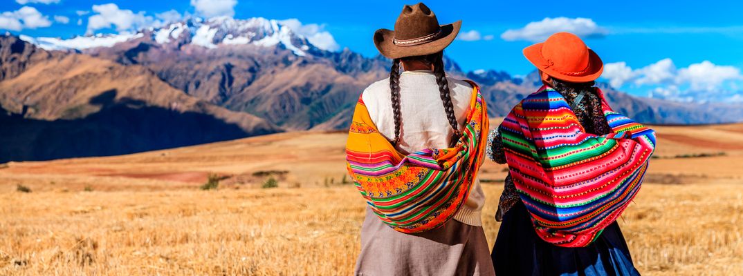Zwei Frauen in traditioneller peruanischer Kleidung betrachten die Landschaft